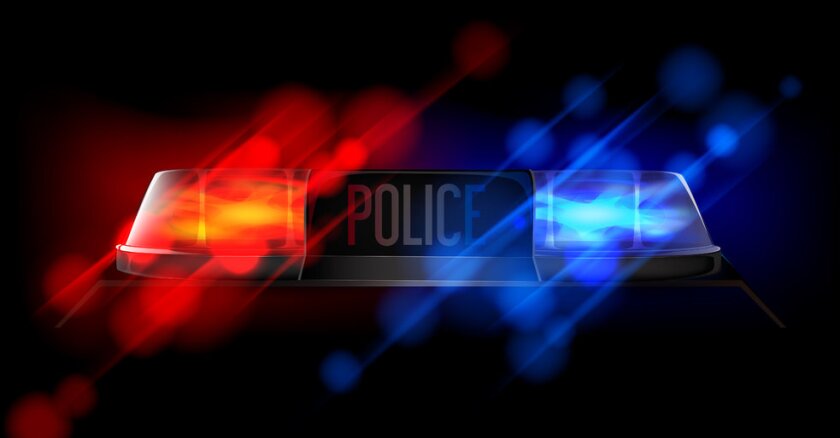 Illuminated lights on a police car in the dark against a black background.