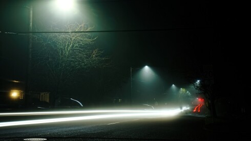 Car speeding down the road at night.