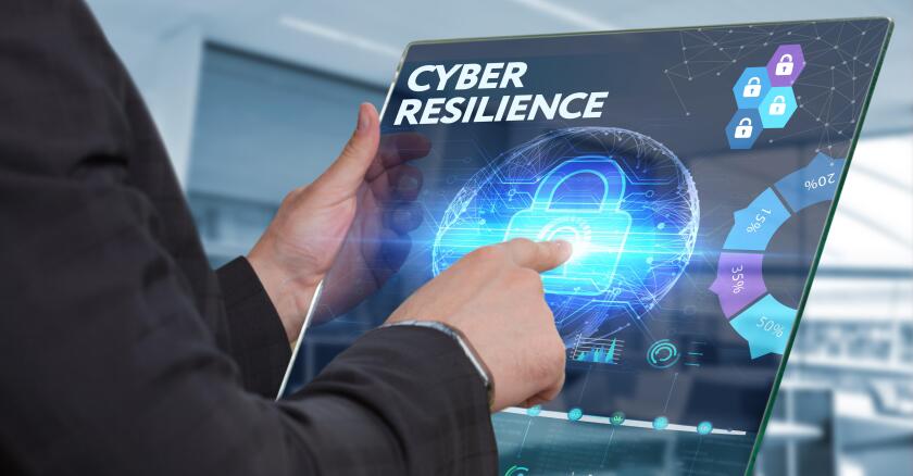 Businessman working on a futuristic tablet that says, "Cyber resilience" on it with symbols of locks and different graphs.