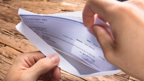 A person opening a paycheck.