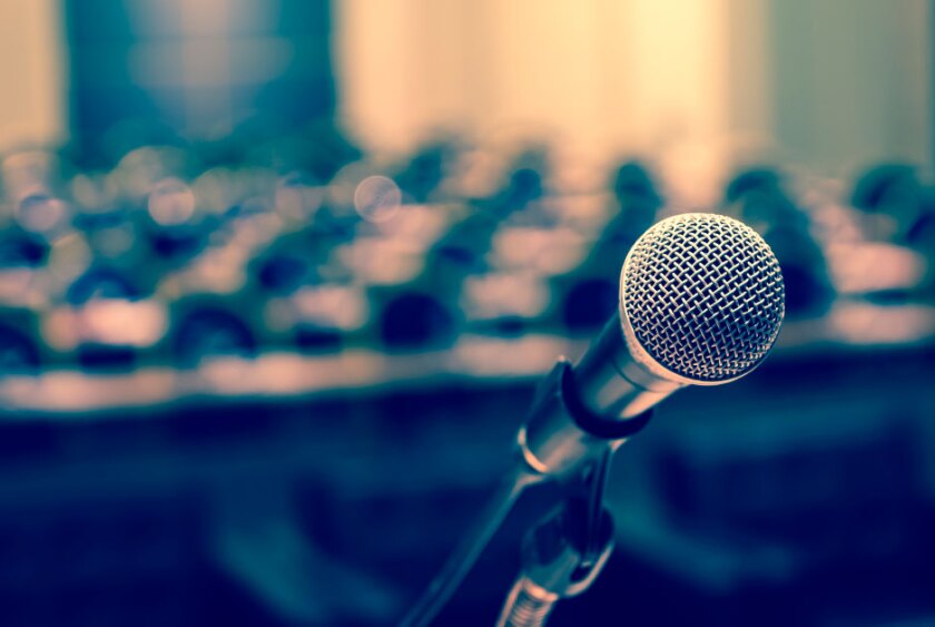 microphone on a dais in front of a room of empty seats