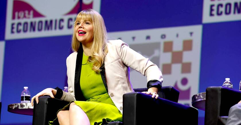 Hilary Doe, Michigan’s first chief growth officer, sitting on a stage at an event speaking.
