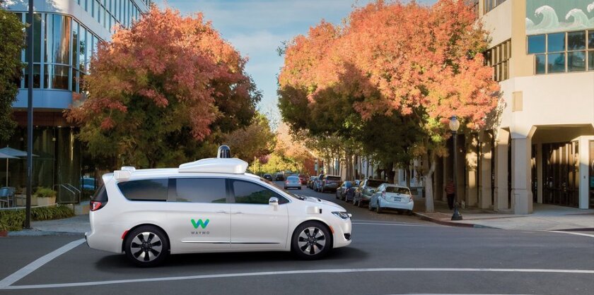 A Waymo driverless taxi on a city street.
