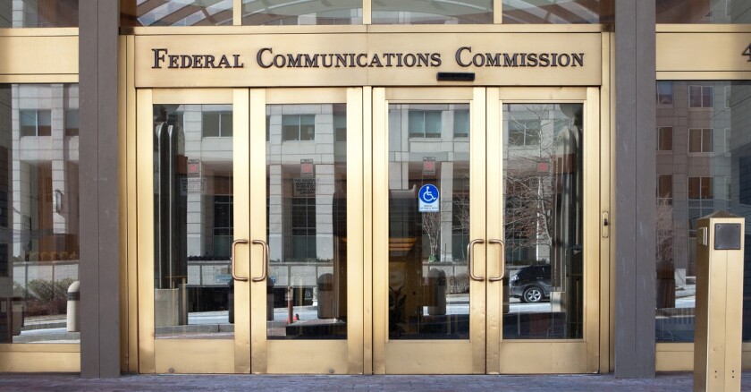The entrance to a building that says "Federal Communications Commission" over the doors..