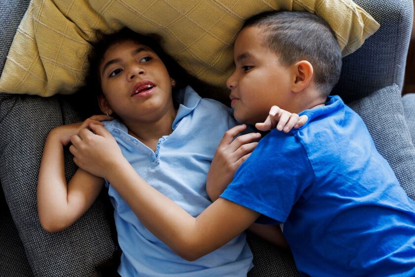 a boy holds his younger sister