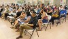 People seated in chairs in rows at a community meeting in Sacramento.