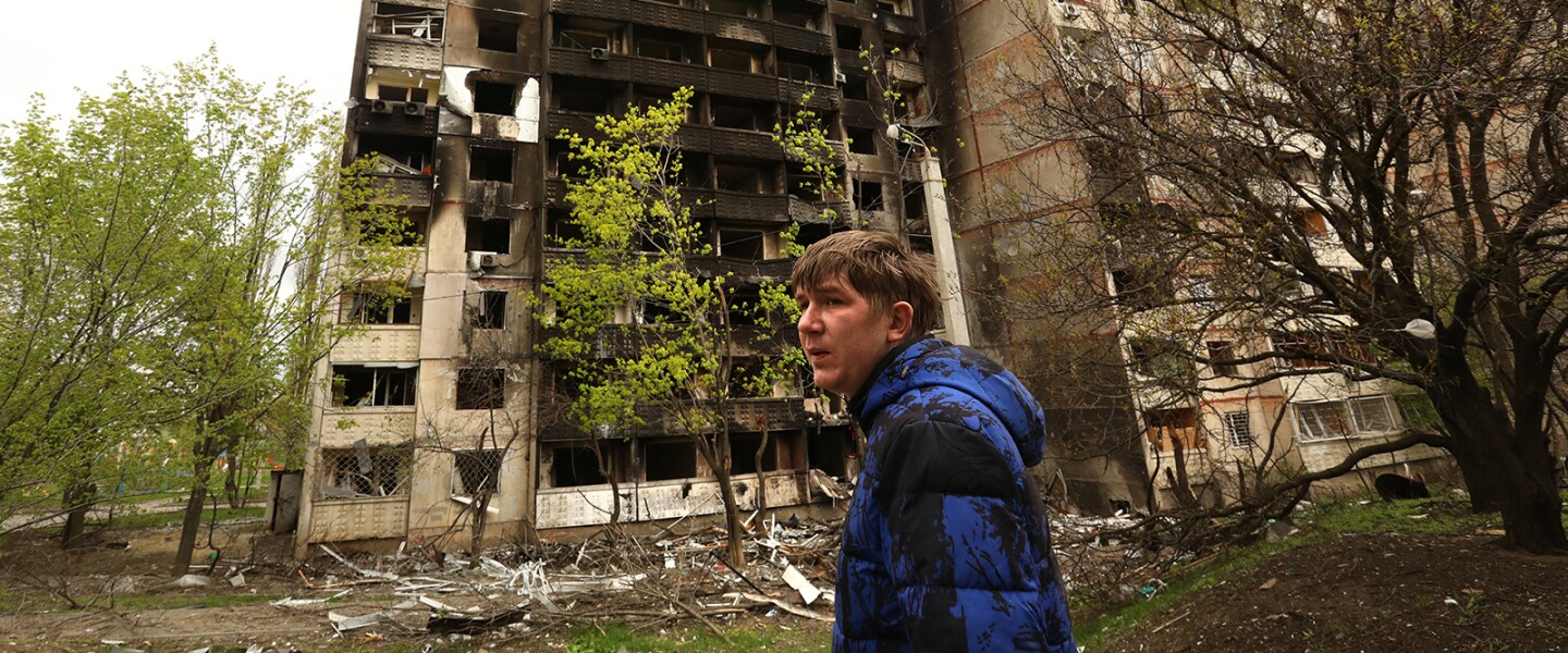 Gennady Krasavtsev standing outside a shelled building in the neighborhood of Saltivske in Kharkiv, Ukraine.