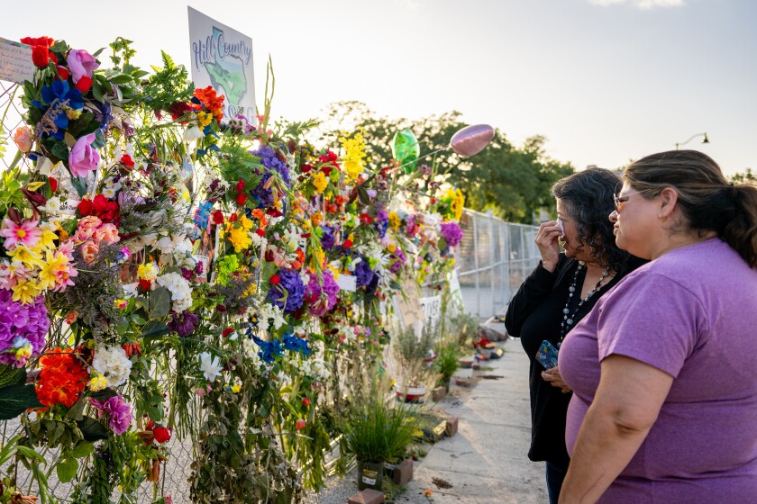 People pay their respects at a makeshift memorial to the victims of the flash floods that claimed at least 120 lives in the central part of the state on July 10, 2025, in Kerrville, Texas. (Brandon Bell/Getty Images/TNS)