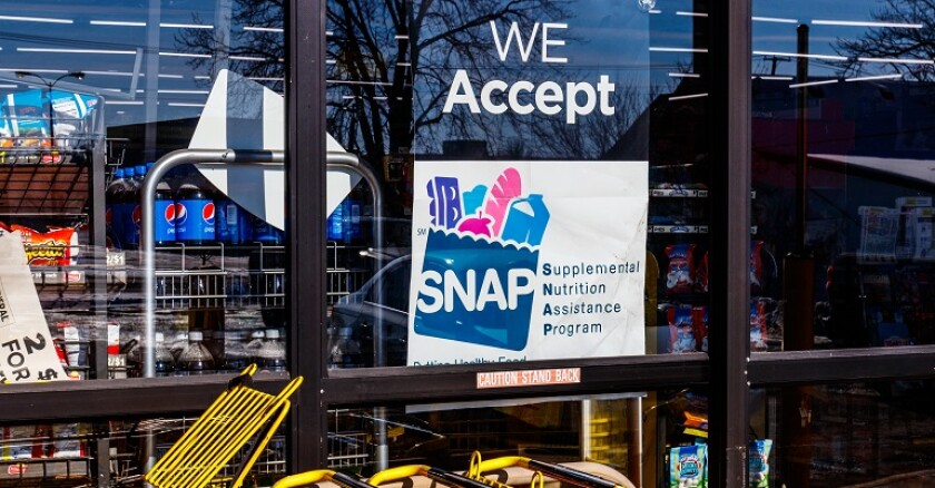 A sign in a store window that says, "We accept SNAP."