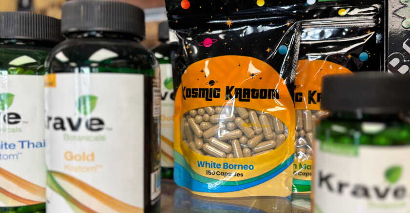 A shelf featuring packages of kratom tablets for sale.