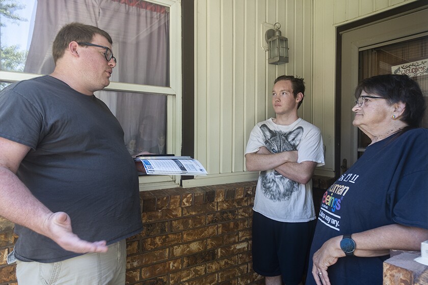 Volunteer Paul Brink speaking with two Wichita residents.