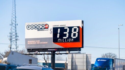 An advertisement for a powerball lottery in Virginia on a large sign next to a busy freeway.