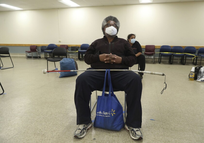 A man in a mask sits in a cooling center in Chicago