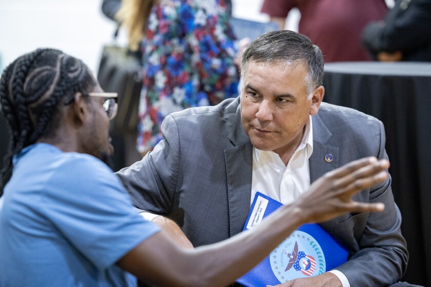 Columbus, Ohio, Mayor Andrew Ginther speaking with a constituent at a local science fair.