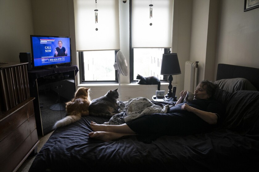A woman laying on a bed with fans on
