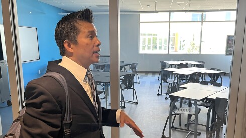 Principal Larry Natividad stands outside a new Compton High School “learning studio,” explaining that teachers will not have their own classroom when the campus opens in the fall, but will share these studios for teaching purposes, in the manner of college lecture halls. (Howard Blume/Los Angeles Times/TNS)