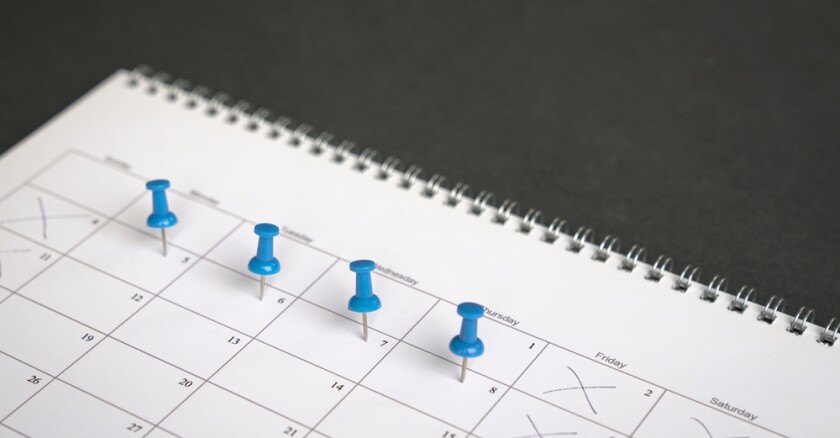 blue pins on a calendar to show a four day work week