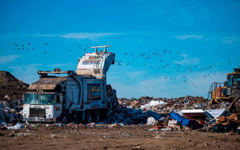An Atlas Disposal garbage truck that claims to be powered by natural gas empties a load of trash at the Yolo County landfill in 2022.