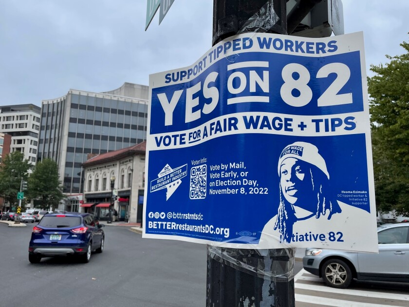 A District of Columbia minimum wage ballot measure sign attached to a street sign pole.