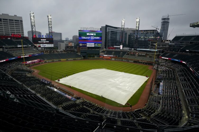 Rain falls onto Truist Park in Atlanta Georgia, where the Braves play baseball, as a tarp covers the infield