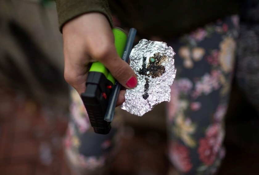 A person holds drug paraphernalia