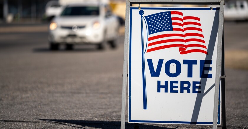 Vote,Here,Sign,In,A,Parking,Lot
