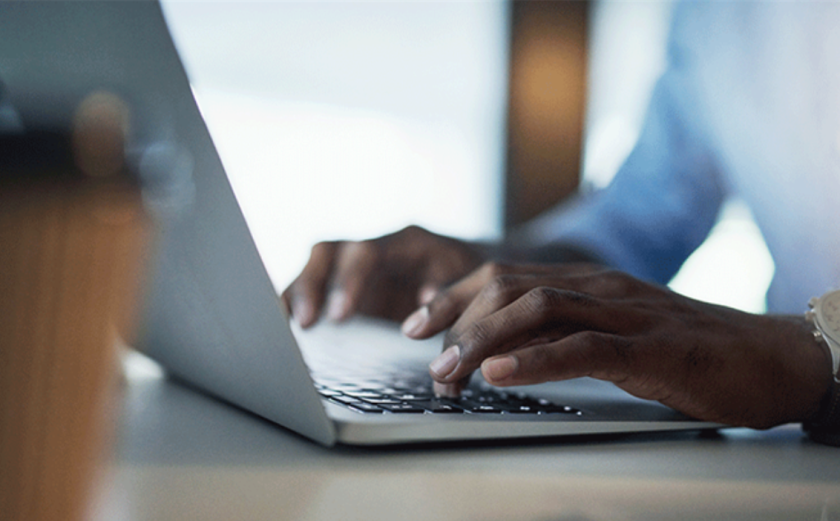 Closeup of a person typing on a laptop.