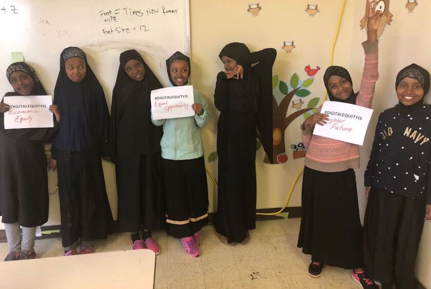 girls holding signs that read #DigitalEquityIs
