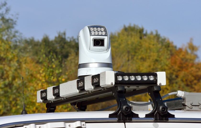 A surveillance camera mounted on top of a police car.