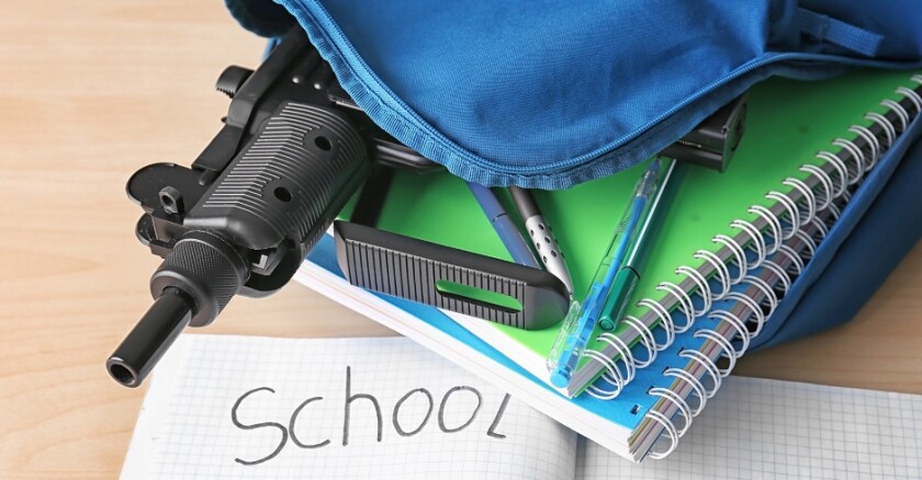 An open backpack with notebooks, a pen, and a gun inside it. An open notebook is beside it with the word "school" written on it.