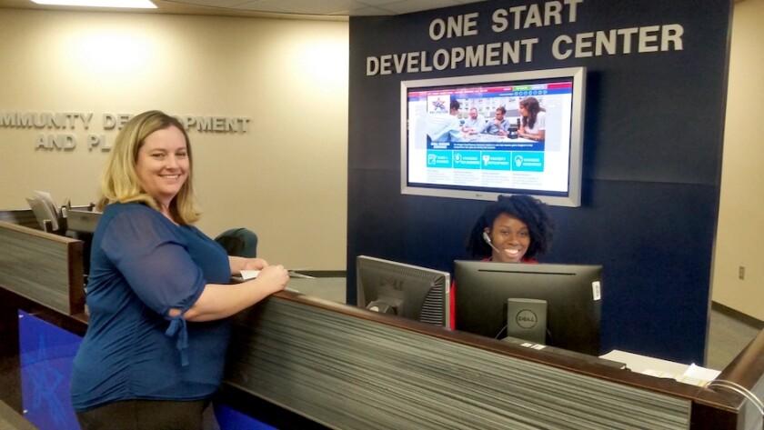 Two women at the welcome desk at the One Start Development Center.