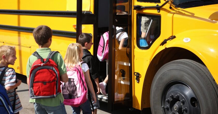 Children getting on a school bus.