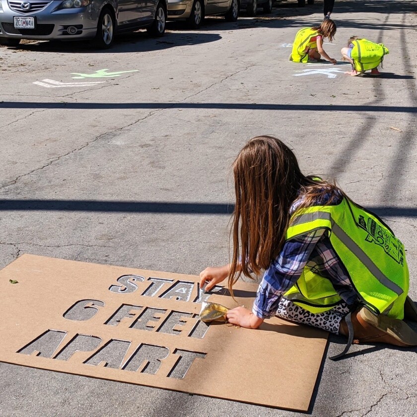 A+girl+stencils+%22Stay+6+Feet+Apart%22+in+a+Kansas+City%27s+Open+Streets+program