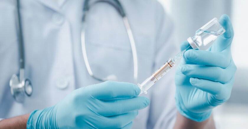 a medical professional pulls vaccine into a syringe