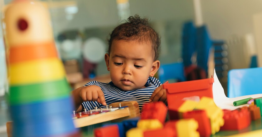 Happy baby playing with toy blocks.