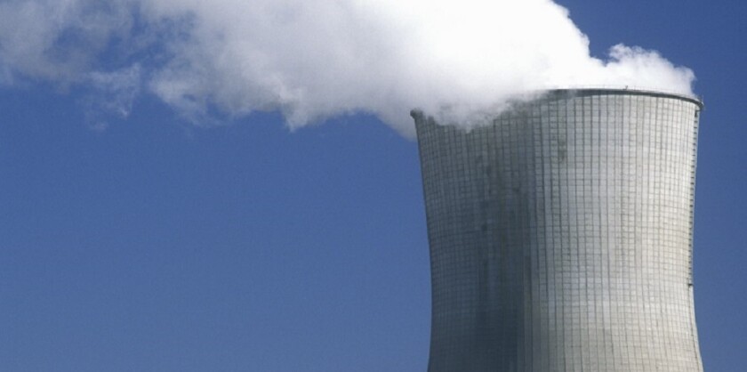 Exhaust coming out of the top of a nuclear reactor against a blue sky.