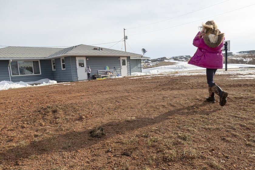 A woman walking toward Horse Creek, one of the few remaining one-room schools in North Dakota.