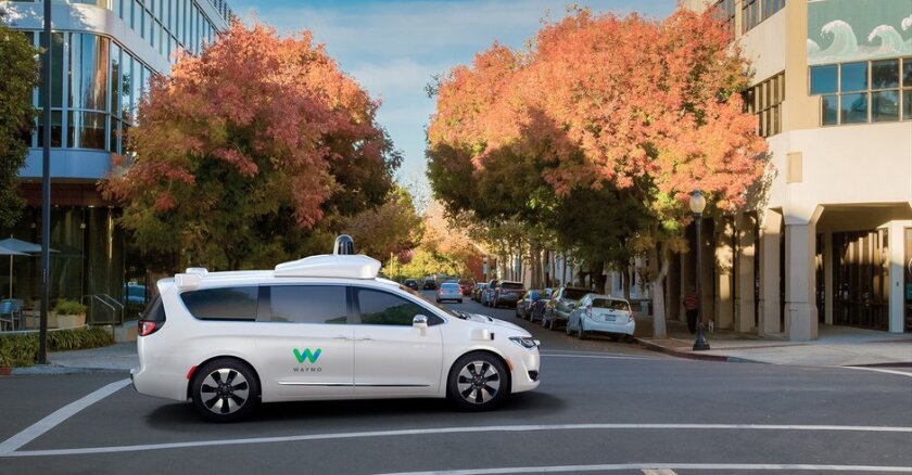 A Waymo driverless taxi on a city street.