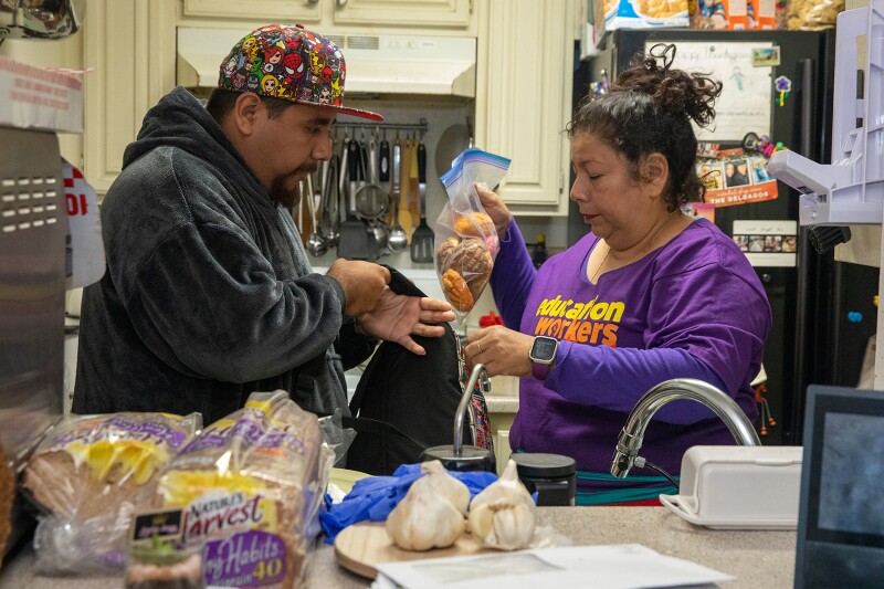 Yadira Martinez gives her 24-year-old son Leonardo Hernandez food she prepared for picketers