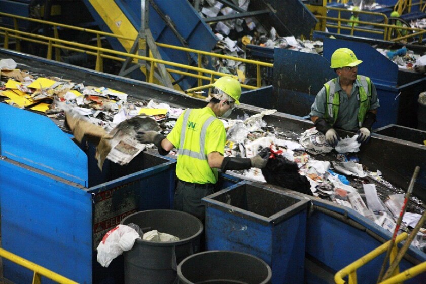Two men work in a recycling facility
