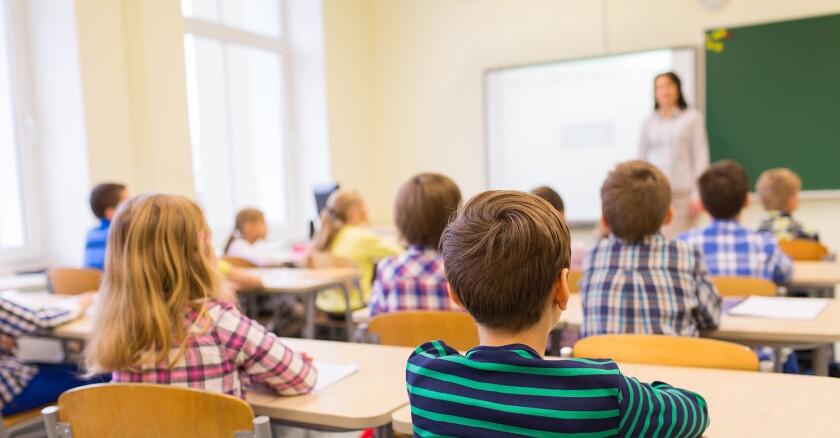 group of school kids and teacher in classroom
