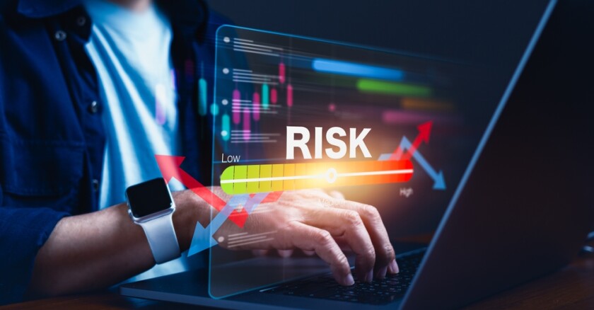Hands on a laptop with a graphic indicating risk or threat level.