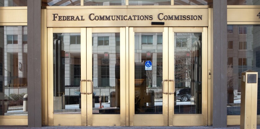 The entrance to a building that says "Federal Communications Commission" over the doors..