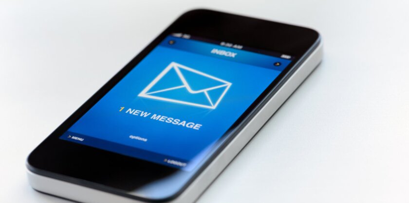 A smartphone laying on a white surface with a notification on it's screen that reads "1 new message."