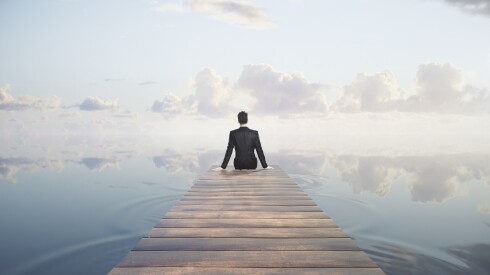 Thoughtful,Businessman,Sitting,At,The,End,Of,Pier,On,Sky