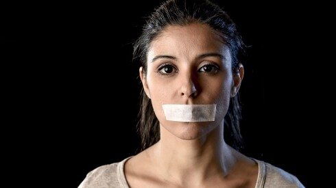 Woman with tape over her mouth.