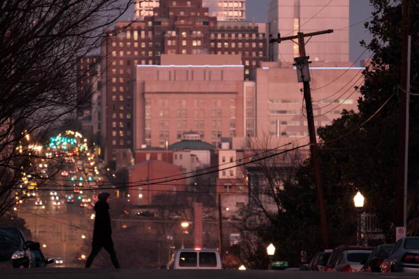 A pedestrian crosses Broad Street in Richmond, Va.
