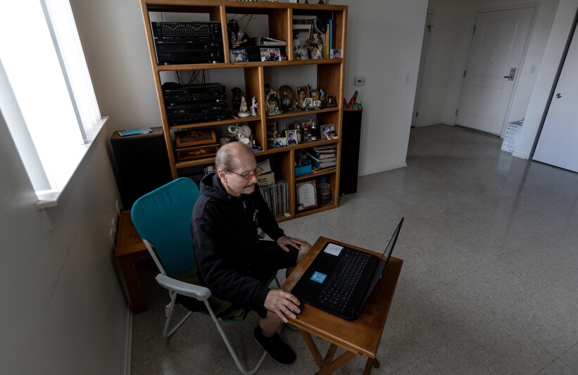 Henry Argueta sits in an unfurnished room