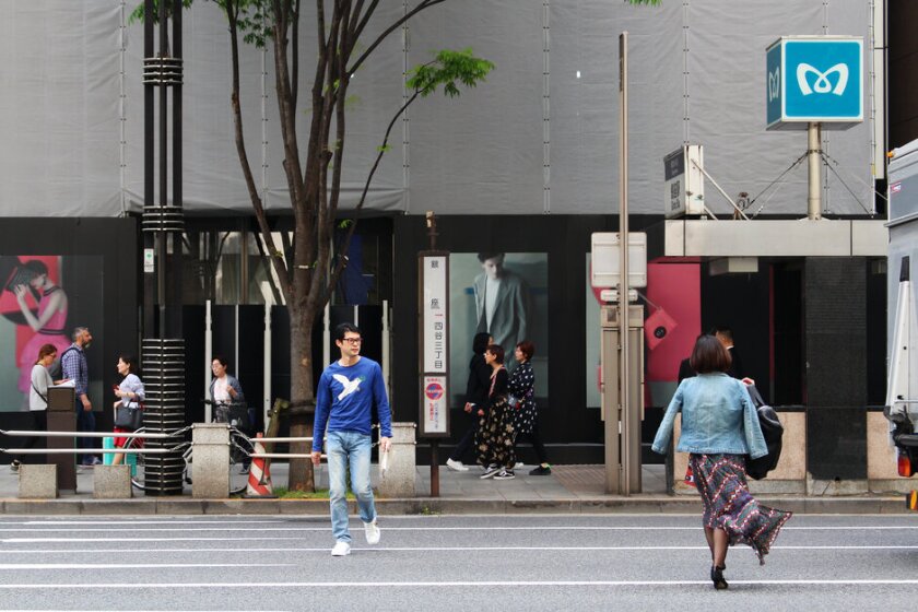 People jaywalking in the middle of a busy street.