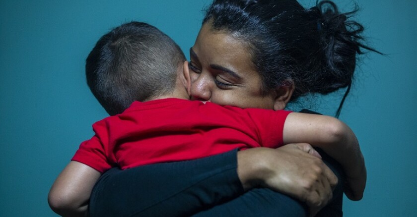 Woman hugging a small boy.